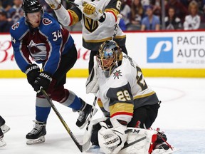Vegas Golden Knights goaltender Marc-Andre Fleury, right, deflects a redirected shot off the stick of Colorado Avalanche center Carl Soderberg in the first period of an NHL hockey game Saturday, March 24, 2018, in Denver.