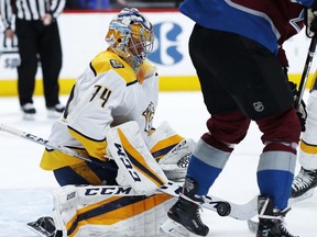 Nashville Predators goaltender Juuse Saros, left, makes a stick save of a redirected shot off the stick of Colorado Avalanche center Carl Soderberg during the first period of an NHL hockey game Friday, March 16, 2018, in Denver.