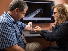 Wendy Hill, a research occupational therapist with the Institute of Biomedical Engineering at the University of New Brunswick (UNB), right, with client Trent Mundie of Fredericton. Hill is one of the researchers at UNB studying whether virtual reality helps ease phantom pain in those that have lost limbs. UNB is first to be holding trials on the potential treatment, for which worldwide clinical testing will be held.