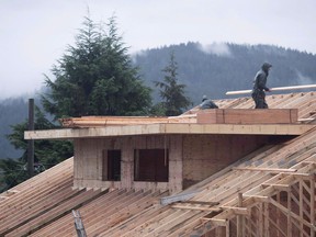 Builders work on a new home in North Vancouver on October 27, 2016. Canada Mortgage and Housing Corp. says the annual pace of housing starts picked up in February compared with January. The agency says the seasonally adjusted annual rate increased to 229,737 units in February, up from 215,260 in January.