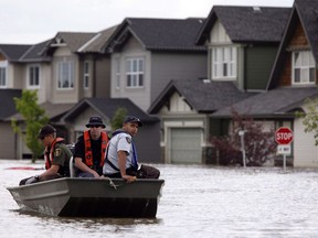 Members of the RCMP return from a boat patrol of a still flooded neighborhood in High River, Alta., on July 4, 2013. A proposed class-action lawsuit against the RCMP over the seizure of guns during the 2013 floods in southern Alberta has been abandoned due to lack of interest.