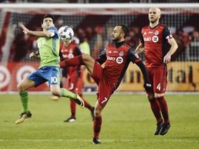 Toronto FC midfielder Victor Vazquez (7) plays the ball as Seattle Sounders midfielder Nicolas Lodeiro (10) defends and Toronto FC midfielder Michael Bradley (4) looks on during second half MLS Cup Final soccer action in Toronto on Saturday, December 9, 2017. oronto FC has re-signed Spanish playmaker Victor Vazquez to a multi-year contract extension.