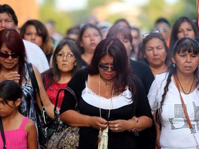 Tina Fontaine, centre, attends a vigil for her daughter Tina Fontaine and Faron Hall at the Oodena Circle at The Forks in Winnipeg, Manitoba, Tuesday, August 19, 2014. A 24-hour safe space for youth in Winnipeg has been dedicated to the memory of Tina Fontaine, a young Indigenous girl whose body was found in the Red River in 2014.