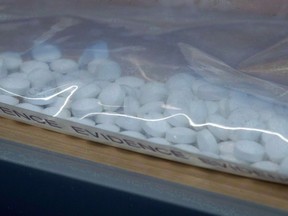 Fake Oxycontin pills containing fentanyl are displayed during a news conference at RCMP headquarters in Surrey, B.C., on Thursday, September 3, 2015.