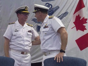 Royal Canadian Navy Vice-Admiral Mark Norman, left, speaks with Vice-Admiral Ron Lloyd during a change of command ceremony in Ottawa on June 23, 2016. The RCMP has charged Vice-Admiral Mark Norman with one count of breach of trust.