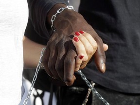Demonstrators hold hands during a pro-migrants and against racism demonstration, organized by a number of leftist organizations including labor unions, Amnesty International and MSF (Doctors Without Borders) in Rome on October 21, 2017. Canadians appear split on whether they hold a collective responsibility for historic injustices towards Indigenous Peoples, according to polling data being released today that provides some insights on non-Indigenous views of reconciliation. When respondents to the poll were asked "all Canadians" share responsibility for the past wrongs like the residential school system, 48.5 per cent either somewhat or strongly agreed.