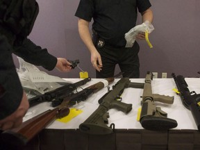 OPP officers prepare to bag a firearm after Ontario Provincial Police host a news conference in Vaughan, Ont., on Thursday, February 23, 2017. The Liberals are planning to introduce legislation in coming weeks to fulfil platform promises on firearms, including a requirement for "enhanced background checks" for anyone seeking to buy a handgun or other restricted gun.THE CANADIAN PRESS/Chris Young