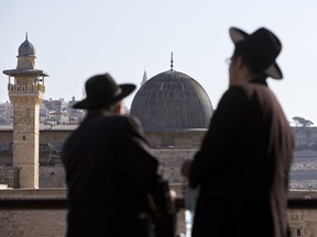 In this Sunday, Oct. 12, 2014 file photo, ultra-Orthodox Jewish men stand in front of the Al-Aqsa Mosque in Jerusalem's Old City.