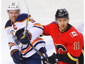 Edmonton Oilers captain Connor McDavid (left) battles Calgary Flames forward Mikael Backlund on March 13.