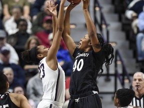 Connecticut's Azura Stevens, left, blocks a shot attempt by Cincinnati's Andeija Puckett, right, during the first half of an NCAA college basketball game in the American Athletic Conference tournament semifinals at Mohegan Sun Arena, Monday, March 5, 2018, in Uncasville, Conn.