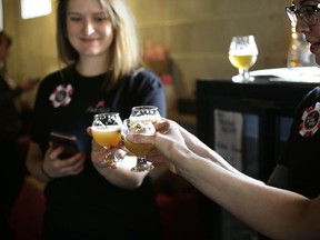 In this Sunday, March 4, 2018, photo, Heather Merson, of Danielson, Conn., left, and Shannon Jutras, of Foster, R.I., right, president of Quiet Corner Home Brew Club, raise their glasses in a toast after helping brew a batch of beer at Black Pond Brews brewery, in Danielson, Conn. The brewery hosted homebrewers and beer enthusiasts for a Pink Boots Society event in honor of International Women's Day, on March 8.