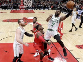 Boston Celtics' Jaylen Brown (7) shoots over Chicago Bulls' Bobby Portis as Aron Baynes, left, watches during the first half of an NBA basketball game Monday, March 5, 2018, in Chicago.