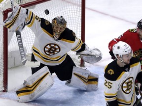 Boston Bruins goalie Anton Khudobin, left, blocks a shot by Chicago Blackhawks right wing Patrick Kane during the first period of an NHL hockey game Sunday, March 11, 2018, in Chicago.