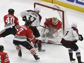 Chicago Blackhawks goaltender Anton Forsberg (31) makes a save on Colorado Avalanche left wing J.T. Compher (37) during the first period of an NHL hockey game Tuesday, March 20, 2018, in Chicago.