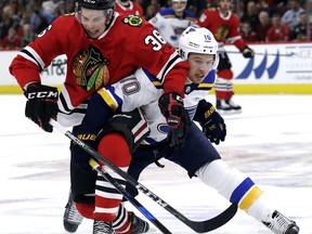 Chicago Blackhawks center Matthew Highmore, left, and St. Louis Blues center Brayden Schenn battle for the puck during the second period of an NHL hockey game Sunday, March 18, 2018, in Chicago.