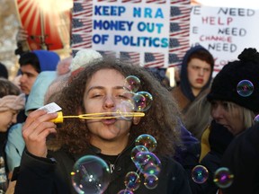 J.J. Miller, 17, of Baltimore, Md., blows bubbles as crowds arrive for the "March for Our Lives" rally in support of gun control, Saturday, March 24, 2018, in Washington.