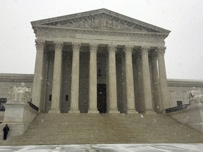 The Supreme Court begins to receive a Spring snow fall, Wednesday morning, March 21, 2018 in Washington.  Although the court is open for business today, the coming spring nor'easter caused the federal government to close its offices in the Washington area.