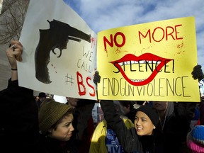 Sofia Briceno, left, and Josie Dang hold banners during the "March for Our Lives" rally in support of gun control in Washington on March 24, 2018.