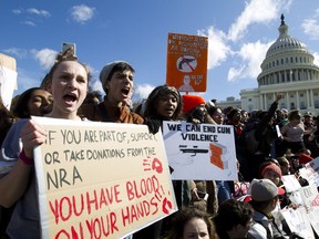 Students hold up their signs during a rally asking for gun control outside of the U.S. Capitol building, in Wednesday, March 14, 2018, in Washington. One month after a mass shooting in Florida, students and advocates across the country participate in walkouts and protests to call on Congress for action.