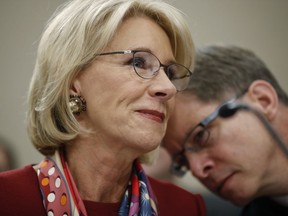 Education Secretary Betsy DeVos, left, leans over to listens to Bill Cordes, right, Dept. of Education Budget Service Elementary, Secondary and Vocational Analysis Division Director, as they wait to testify before a House Committee on Appropriation subcommittee hearing on Capitol Hill in Washington, Tuesday, March 20, 2018.