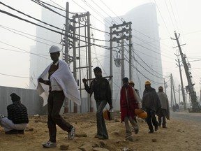 In this Dec. 22, 2011 file photo, workers head to a construction site in Gurgaon, India. An Indian company that is partnering with the Trump Organization on an office tower project has been accused of running an elaborate real estate swindle that cheated investors out of nearly $150 million, according to complaints filed with Indian authorities.