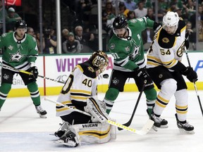 Boston Bruins goalie Tuukka Rask (40) tracks an airborne puck that bounced off his chest under pressure from Dallas Stars center Tyler Seguin (91) as defenseman Adam McQuaid (54) helps defend on the play in the firstperiod of an NHL hockey game in Dallas, Friday March 23, 2018.