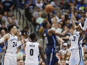 Dallas Mavericks forward Harrison Barnes (40) attempts a shot as Memphis Grizzlies guard Ben McLemore (23) and forwards JaMychal Green (0) and Dillon Brooks (24) defend during the first half of an NBA basketball game, Saturday, March 10, 2018, in Dallas.