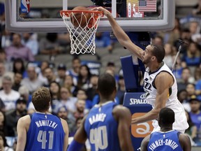 Utah Jazz center Rudy Gobert (27) dunks as Dallas Mavericks' Dirk Nowitzki (41), of Germany; Harrison Barnes (40); and Dorian Finney-Smith, right, watch during the first half of an NBA basketball game Thursday, March 22, 2018, in Dallas.