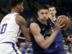 Orlando Magic's Nikola Vucevic, right, drives around Phoenix Suns' Marquese Chriss (0) during the first half of an NBA basketball game, Saturday, March 24, 2018, in Orlando, Fla.