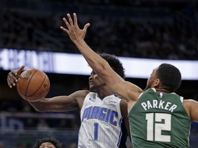 Orlando Magic's Jonathan Isaac (1) grabs a rebound away from Milwaukee Bucks' Jabari Parker (12) during the first half of an NBA basketball game Wednesday, March 14, 2018, in Orlando, Fla.