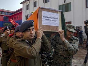 Police and paramilitary officers carry the coffin of their colleague Deepak Thusoo, who was killed in a gun battle with suspected rebels, during a ceremony at the police headquarters in Srinagar, Indian controlled Kashmir, Thursday, March 22, 2018. A fierce gun battle has killed five Indian government forces and five suspected militants in disputed Kashmir, officials said Wednesday.