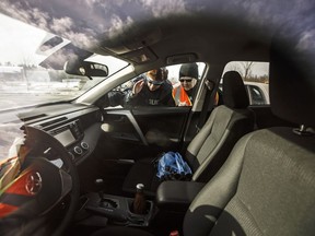 RCMP constable Terra Lisson, left and Alberta Citizens On Patrol Association president Bev Salomons look through cars for valuables to warn the owners about the dangers of leaving valuables in a vehicle, in Ardrossan, Alta., on Tuesday, March 6, 2018.