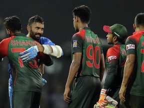Bangladesh's team members congratulate India's Dinesh Karthik, second left, following their lost in the finals of Nidahas triangular Twenty20 cricket series in Colombo, Sri Lanka, Sunday, March 18, 2018.