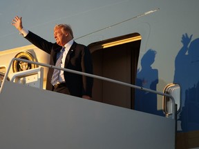 President Donald Trump waves as he arrives on Air Force One with first lady Melania Trump and their son Barron Trump at Palm Beach International Airport, in West Palm Beach, Fla., Friday, March 23, 2018.