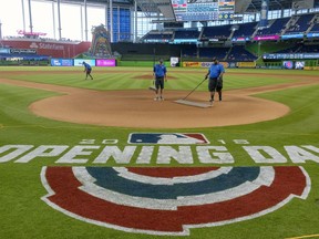 Members of the grounds crew prepare the infield at Marlins Park before the opening day baseball game between the Chicago Cubs and the Miami Marlins, Thursday, March 29, 2018, in Miami.