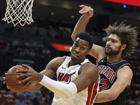 Miami Heat center Hassan Whiteside, left, grabs a defensive rebound in front of Chicago Bulls center Robin Lopez, right, during the first half of an NBA basketball game Thursday, March 29, 2018, in Miami.