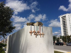 Six crosses are placed at a makeshift memorial on the Florida International University campus in Miami on Saturday, March 17, 2018, near the scene of a pedestrian bridge collapse that killed at least six people on March 15.