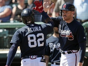 Atlanta Braves' Ronald Acuna Jr. (82) gets high five from Freddie Freeman, right, after hitting a home run in the third inning of a spring baseball exhibition game, Thursday, March 15, 2018, in Kissimmee, Fla.