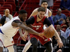 New York Knicks guard Emmanuel Mudiay (1) knocks the ball away from Miami Heat guard Tyler Johnson (8) during the first quarter of an NBA basketball game Wednesday, March 21, 2018, in Miami.