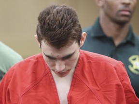 FILE - In a Wednesday, March 14, 2018 file photo, Nikolas Cruz is lead out of the courtroom after an arraignment hearing at the Broward County Courthouse in Fort Lauderdale, Fla. Cruz is accused of the shooting rampage that killed 14 students and three school employees at Marjory Stoneman Douglas High School in Parkland on Feb. 14. In addition, 17 people were wounded. More than a year earlier, documents in the criminal case against Nikolas Cruz and obtained by The Associated Press show school officials and a sheriff's deputy recommended in September 2016 that Cruz be involuntarily committed for a mental evaluation. But the recommendation was never acted upon.