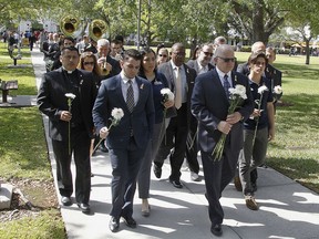 Florida International University President Mark B. Rosenberg, right, students and faculty staff lead a procession on Wednesday, March 21, 2018, as part of a vigil hosted by the FIU student Government Association in Miami. The vigil was for the six people killed when a new pedestrian bridge collapse last Thursday.