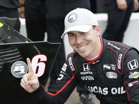 Robert Wickens, of Canada, poses for photos next to his pole-position sticker on his car after taking the pole in qualifying Saturday, March 10, 2018, in St. Petersburg, Fla, for the IndyCar auto race.