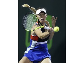 Caroline Wozniacki, of Denmark, returns a shot to Monica Puig, of Puerto Rico, at the Miami Open tennis tournament early Saturday, March 24, 2018, in Key Biscayne, Fla. Puig won 0-6, 6-4, 6-4.