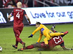 UANL Tigres forward Ismael Sosa (18) receives a sliding tackle from Toronto FC defender Chris Mavinga (23) as Toronto FC midfielder Michael Bradley (4) looks on during second half CONCACAF Champions League quarter-final action, in Toronto on Wednesday, March 7, 2018.
