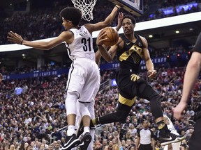 Toronto Raptors guard DeMar DeRozan (10) looks to pass the ball under the net past Brooklyn Nets centre Jarrett Allen (31) during second half NBA basketball action in Toronto on Friday, March 23, 2018.