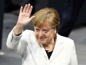 German Chancellor Angela Merkel waves when Germany's parliament Bundestag meets to elect Angela Merkel for a fourth term as chancellor in Berlin, Germany, Wednesday, March 14, 2018.