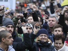 Demonstrators show their key chains during an anti-government rally in Bratislava, Slovakia, Friday, March 9, 2018. The country-wide protests demand a thorough investigation into the shooting deaths of Jan Kuciak and Martina Kusnirova, whose bodies were found in their home on Feb. 25, and changes in the government.