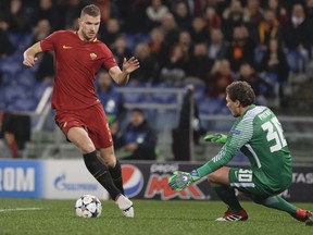 Roma's Edin Dzeko tries to dribble past Shakhtar goalkeeper Andriy Pyatov during a Champions League round of 16 second-leg soccer match between Roma and Shakhtar Donetsk, at the Rome Olympic stadium, Tuesday, March 13, 2018.