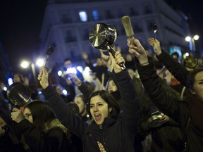 Women bang pots and pans as shooting slogans during a protest marking the beginning of a 24-hour women strike at the Sol square in Madrid, early Thursday, March 8, 2018. Women in Spain have been called for a 24-hour feminist strike in their workplaces and also stop doing duties at home during the International Women's Day.