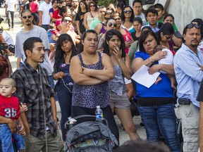 FILE - In this Aug. 15, 2012, file photo, a line of people living in the U.S. without legal permission wait outside the Coalition for Humane Immigrant Rights in Los Angeles. California is suing the Trump administration over its decision to add a question about citizenship to the 2020 U.S. Census. In announcing the lawsuit Tuesday, March 27, 2018, California Attorney General Xavier Becerra says adding such a question is a reckless decision that would violate the U.S. Constitution and cause a population undercount.